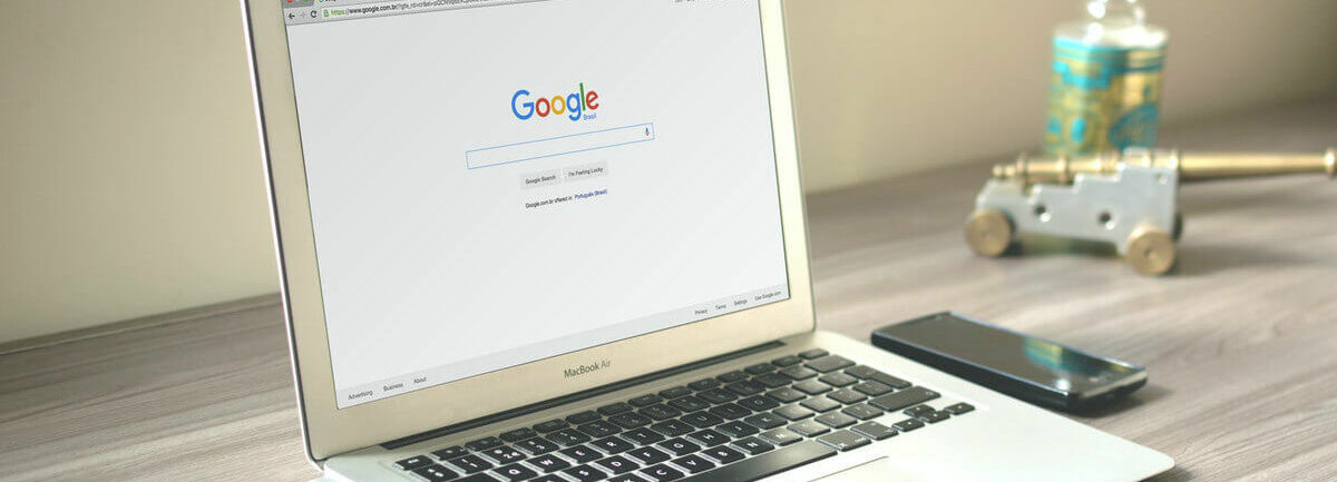 Un ordinateur avec une page d'accueil Google, posé sur un bureau