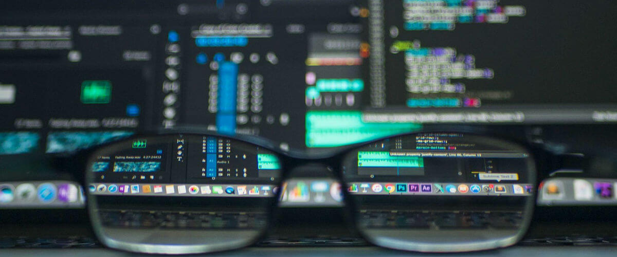Un bureau avec des lunettes et des données informatiques en arrière-plan